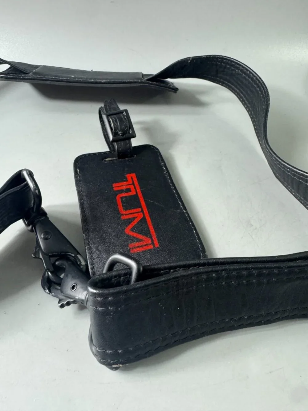 A Bundle of Two (2) Vintage Tumi Black Leather Strap and Travel Tag